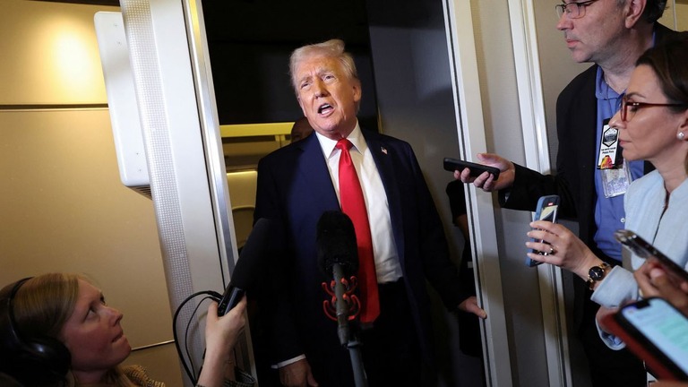ワシントンへ戻るエアフォースワン（大統領専用機）の機内で記者団に答えるトランプ氏/Kevin Lamarque/Reuters